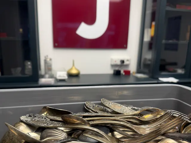 Wanne voller Silberbesteck vor dem roten J-Schild in der JASPERS-Filiale
