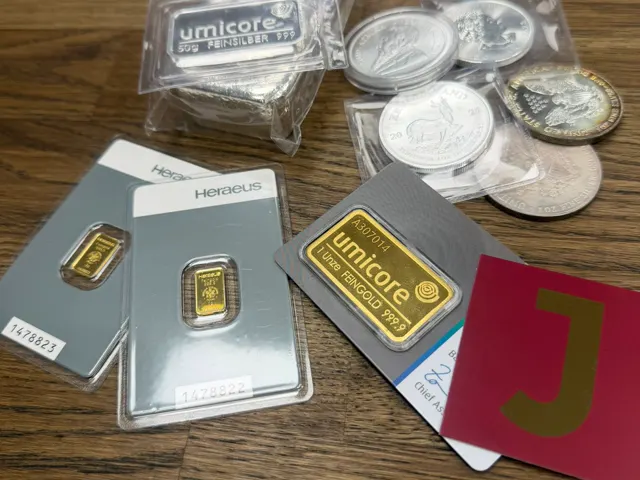 Gold- und Silberbarren mit Krügerrand-Münzen und JASPERS-Karte